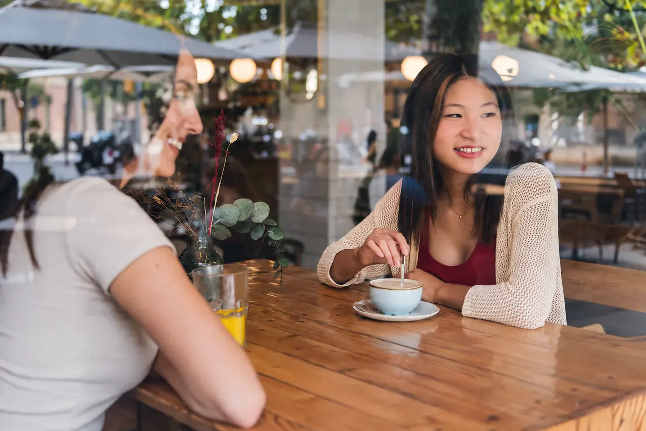 Two people in conversation seen through a glass window